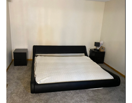 Dark color bed with white blanket on top